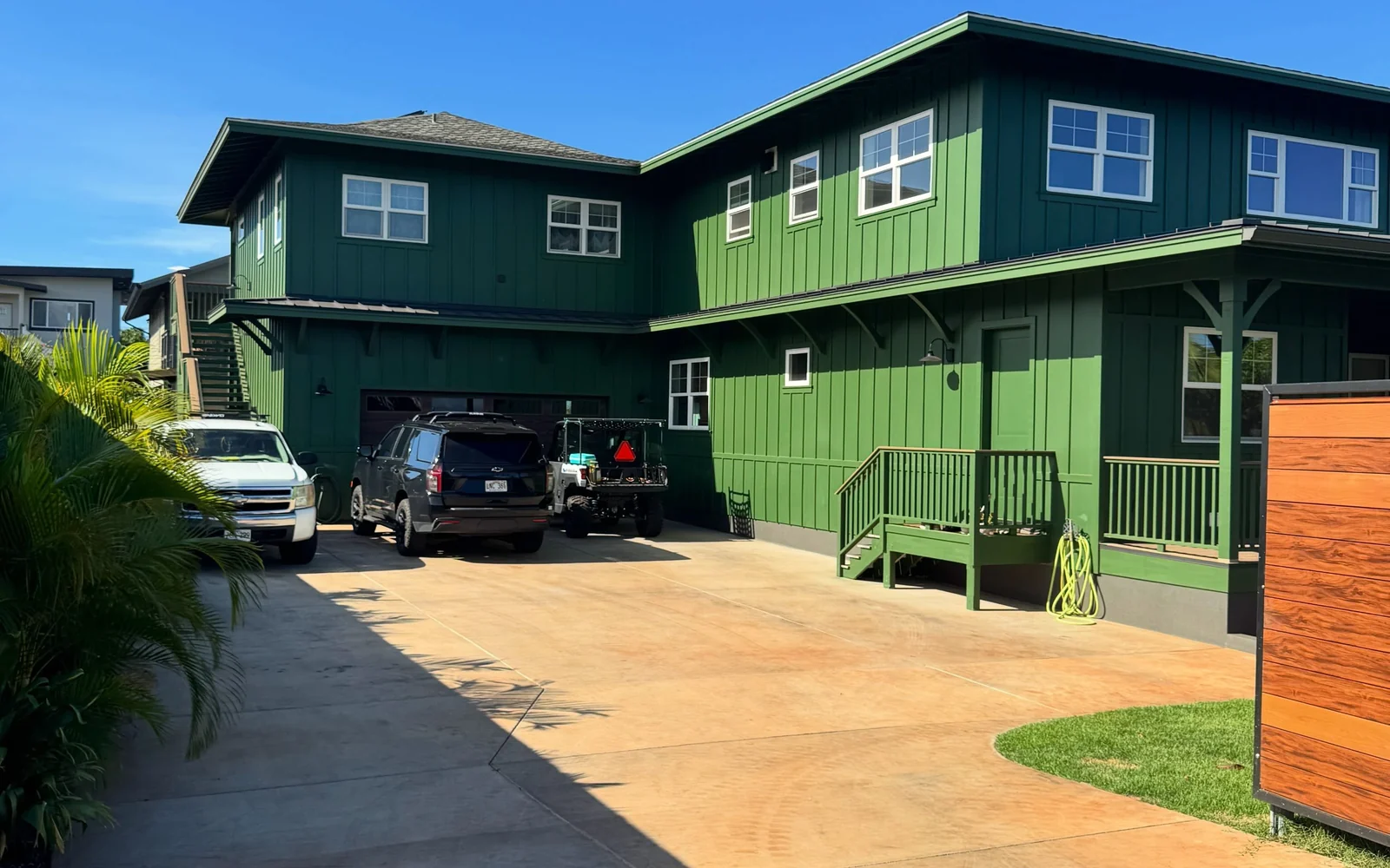 The finished exterior of the two story Maui home, board and batten siding evenly coated.